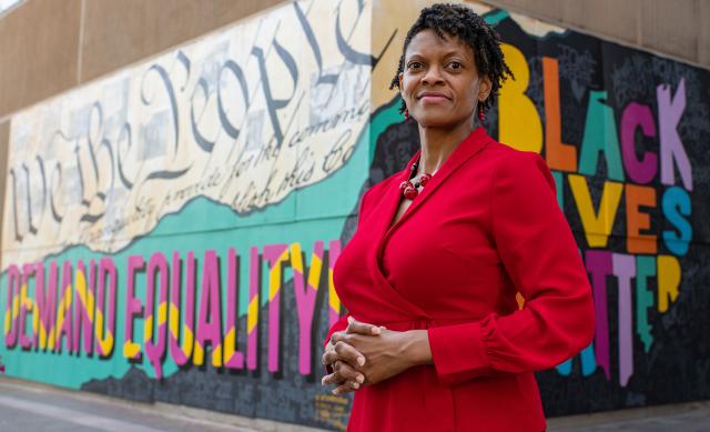 Andrea Williams standing in front of Black Lives Matter street art