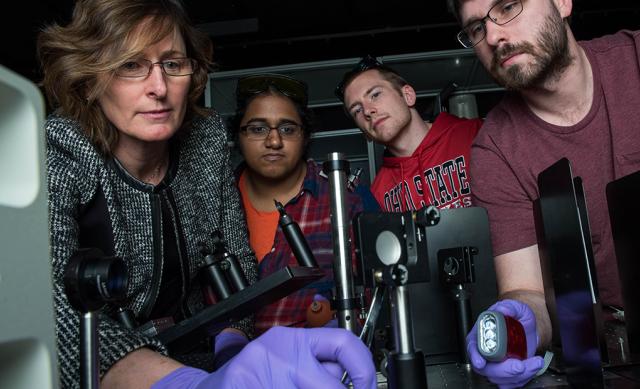 Female faculty member conducts chemistry research with three students