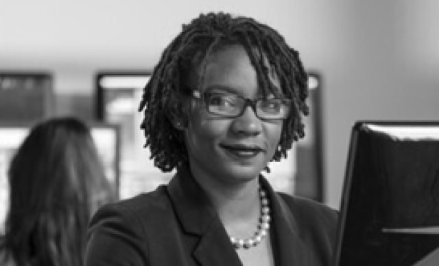 Black and white close up of Black woman with braided hair in an office