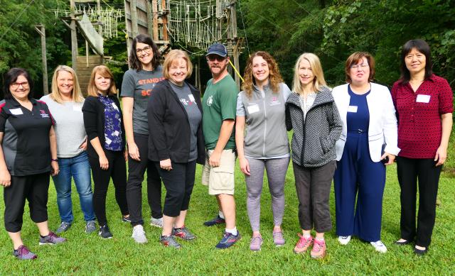 Group of faculty in active wear standing in line facing camera