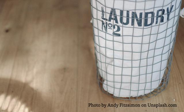 Close up of wire laundry basket with white canvas bag inside