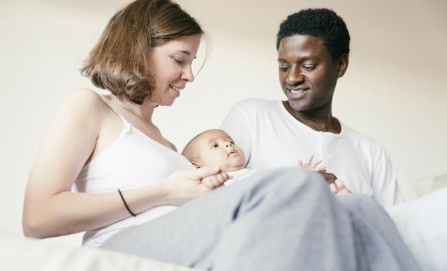Woman and man cuddling their baby