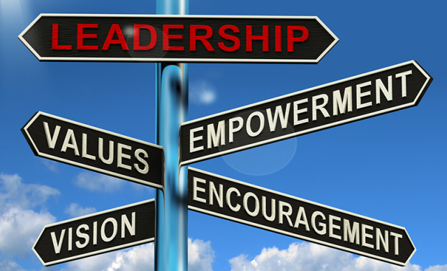 Pole with direction signs and with the word "leadership" at the top and other leadership-related words on signs