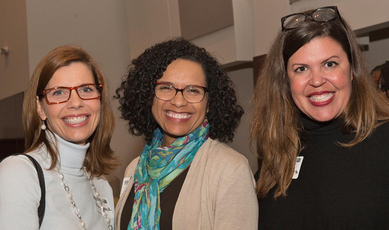 Three women smiling, posing for photo