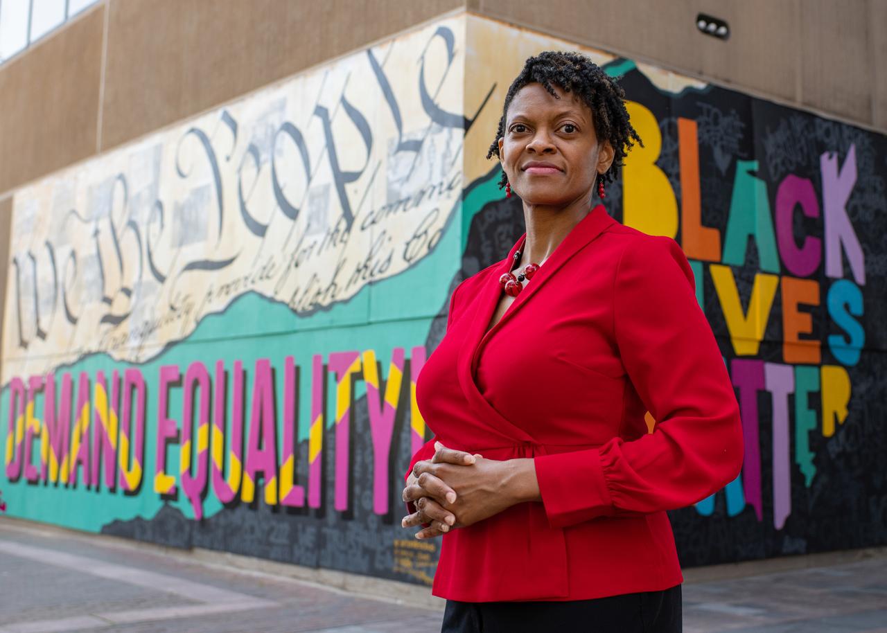 Andrea Williams standing in front of Black Lives Matter street art