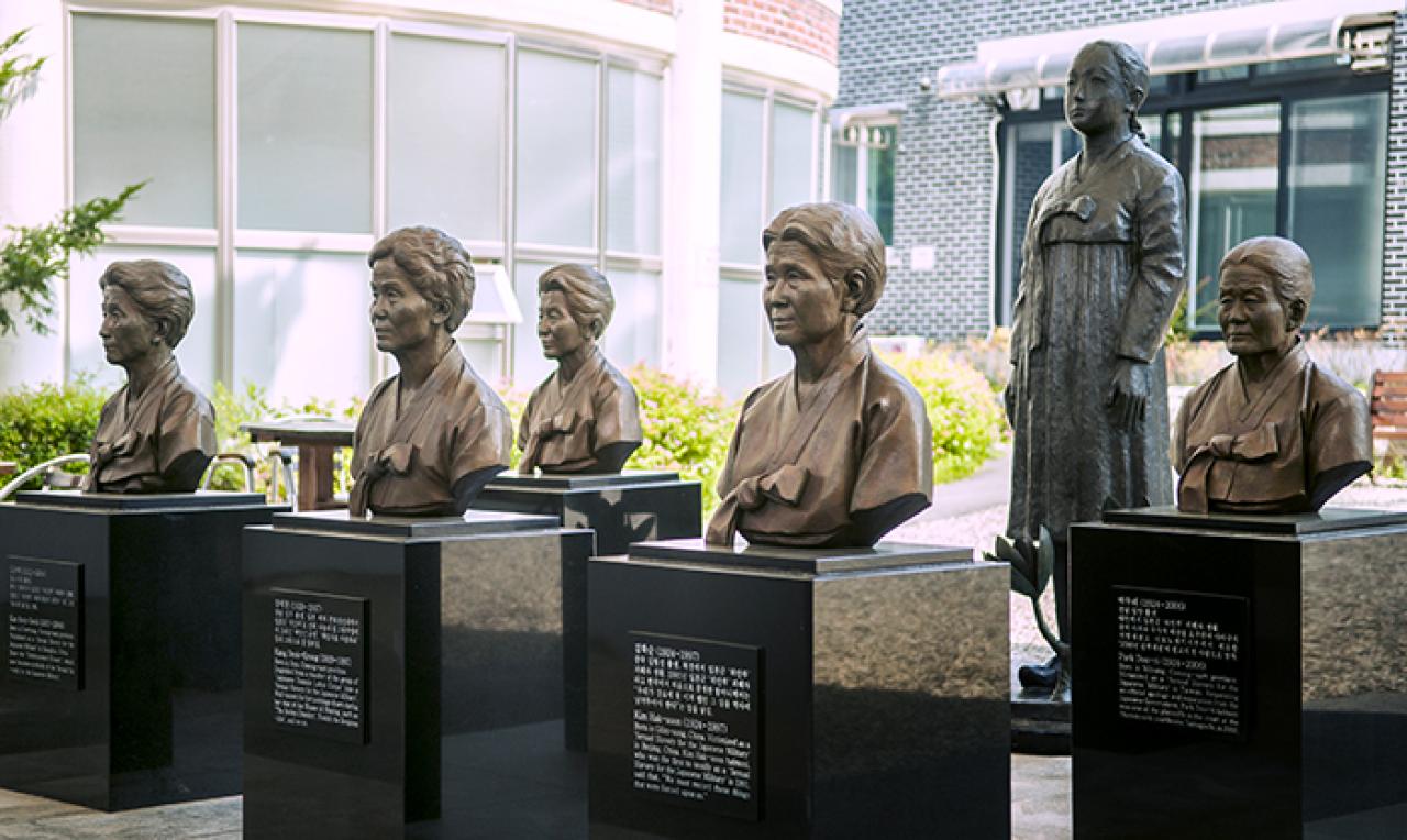 Bronze busts of Korean comfort women mounted on black podiums in two rows
