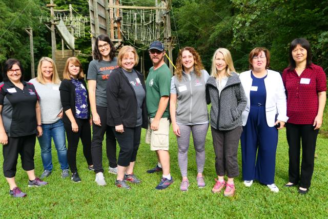 Group of faculty in active wear standing in line facing camera