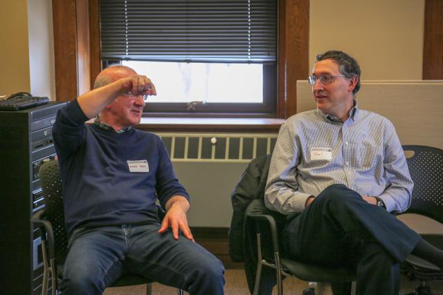 two men have a conversation while seated