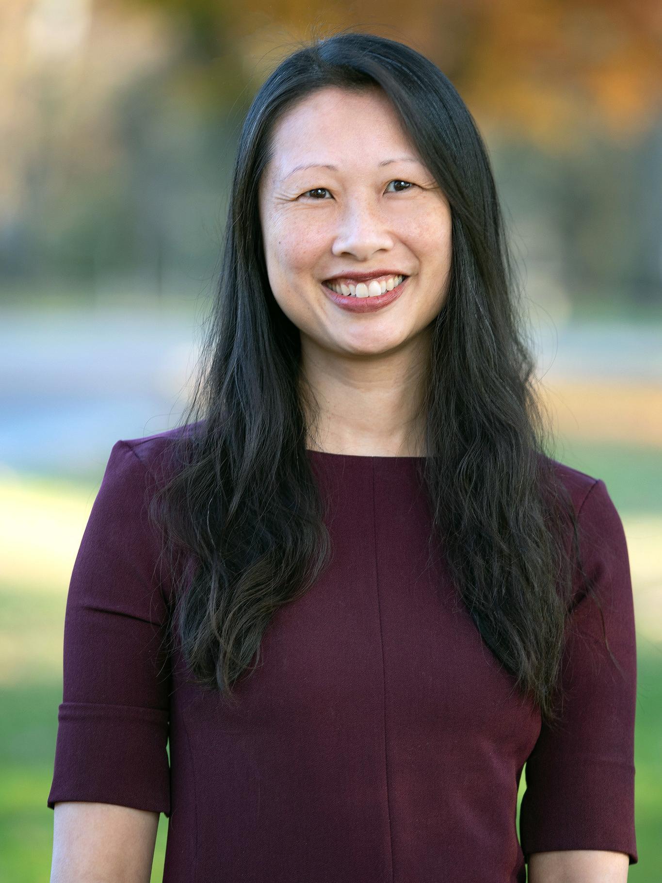 Katrina Lee smiling wearing a dark purple blouse.