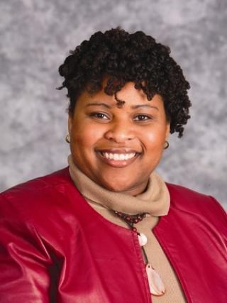 Portrait of Wendy Smooth wearing a red jacket and beige turtle neck 