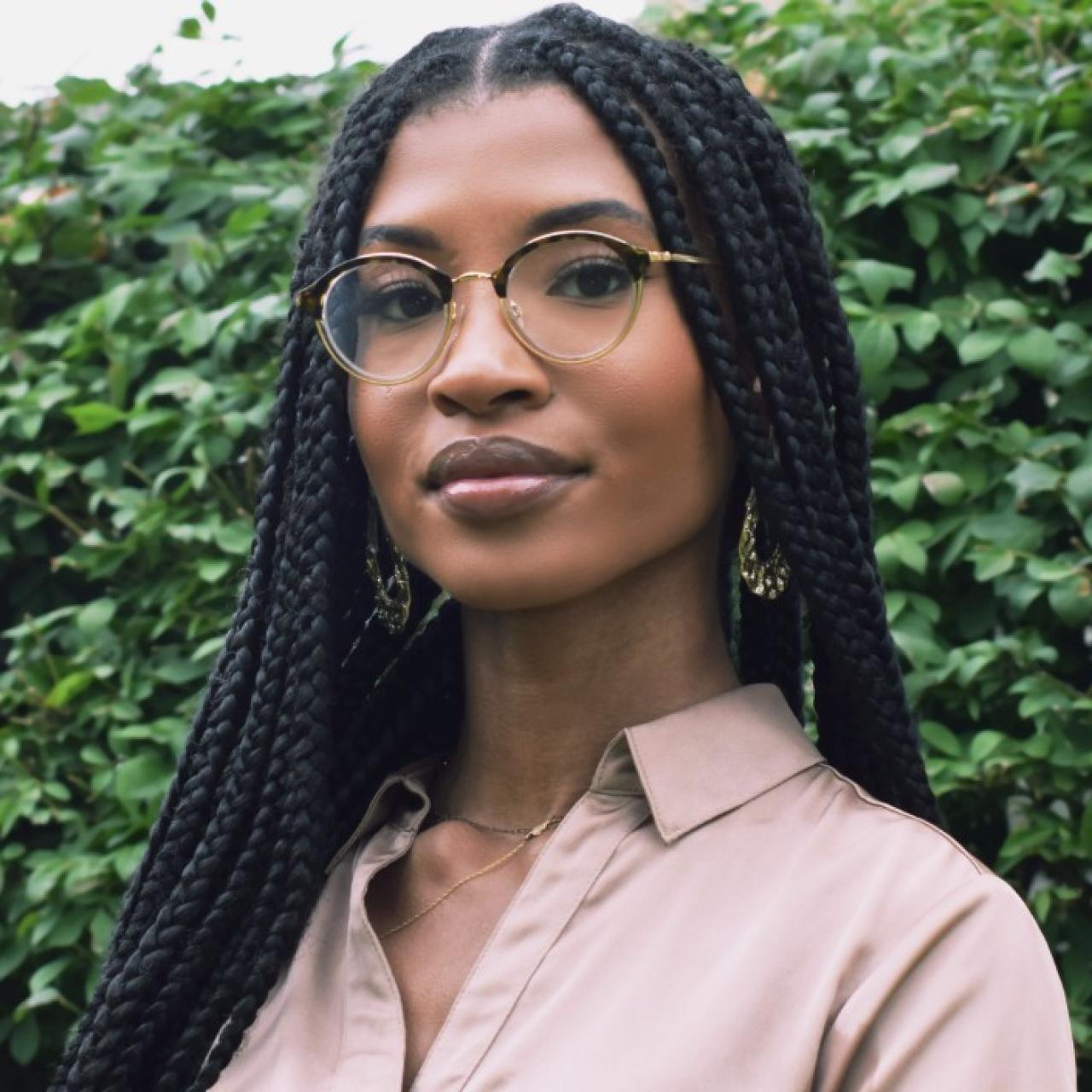 Portrait of Brittney Seals wearing a button down in front of a bush