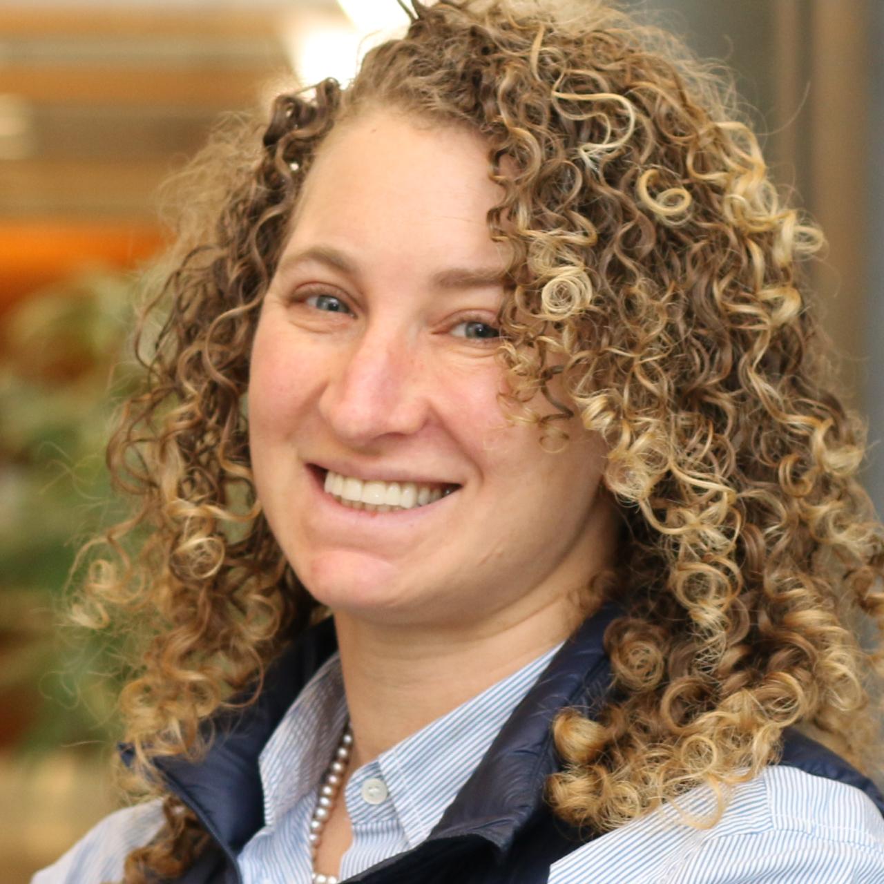 Stephanie Wapner standing in a hallway and smiling. 