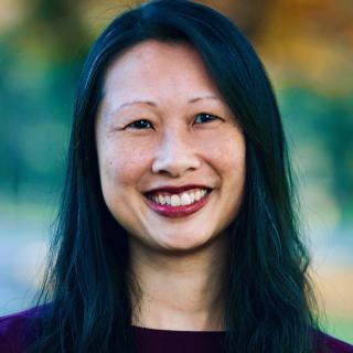 Portrait of Katrina Lee smiling, wearing purple blouse