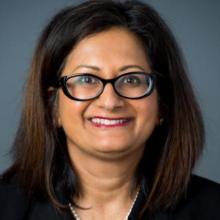 Vidya Raman wearing glasses and smiling