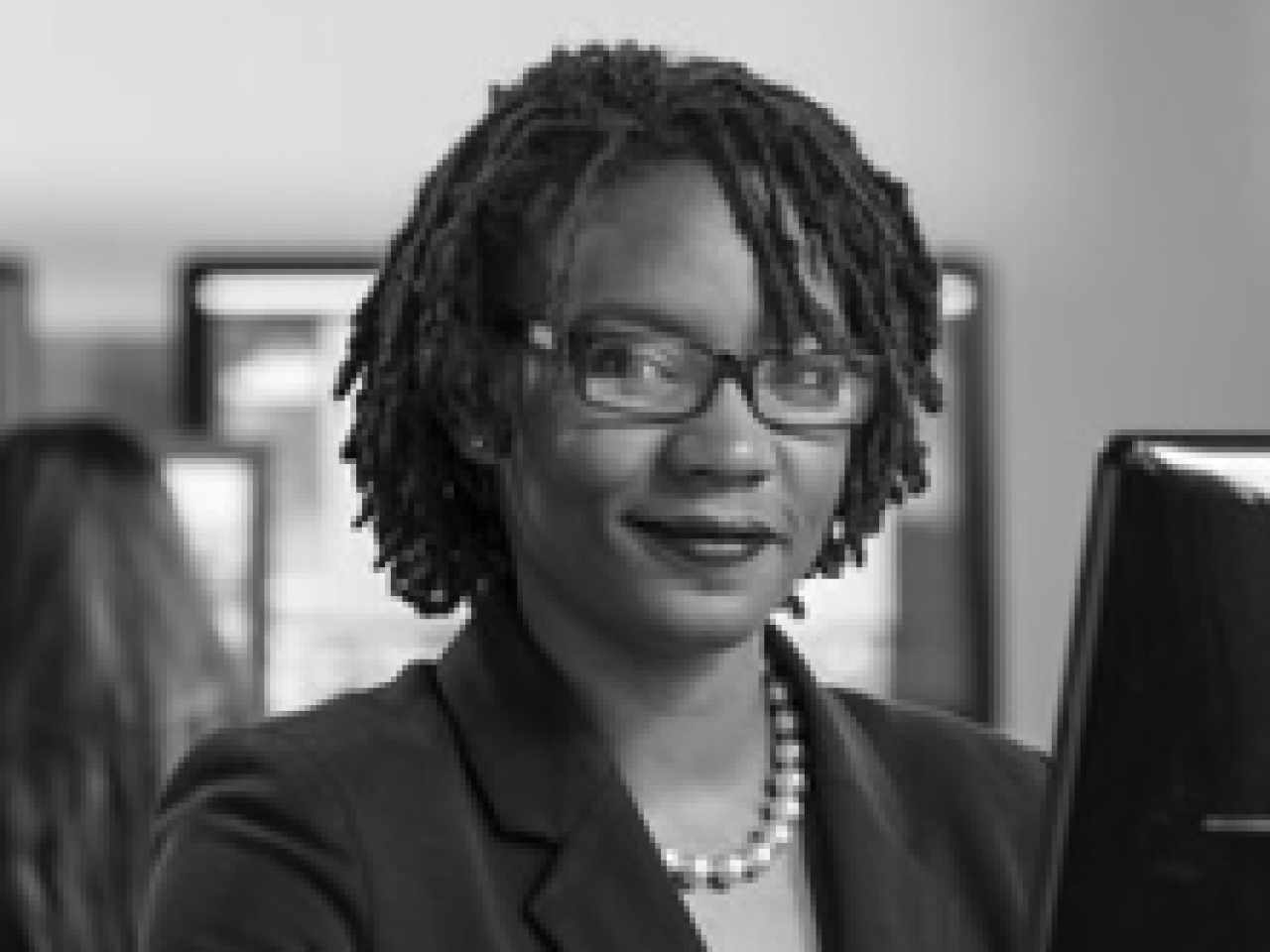 Black and white close up of Black woman with braided hair in an office