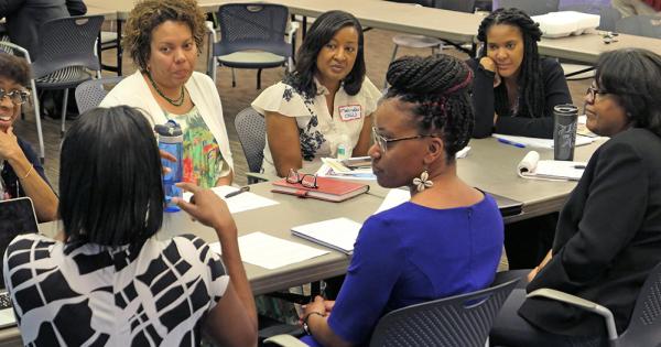 Black women seated at a table having discussion