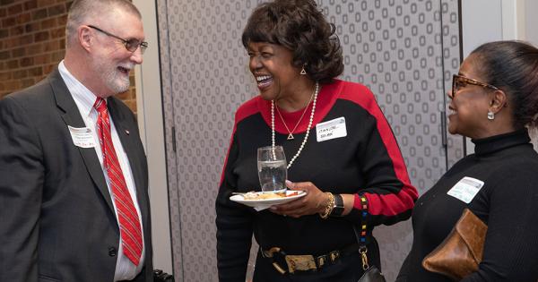 Man and two women in conversation, laughing