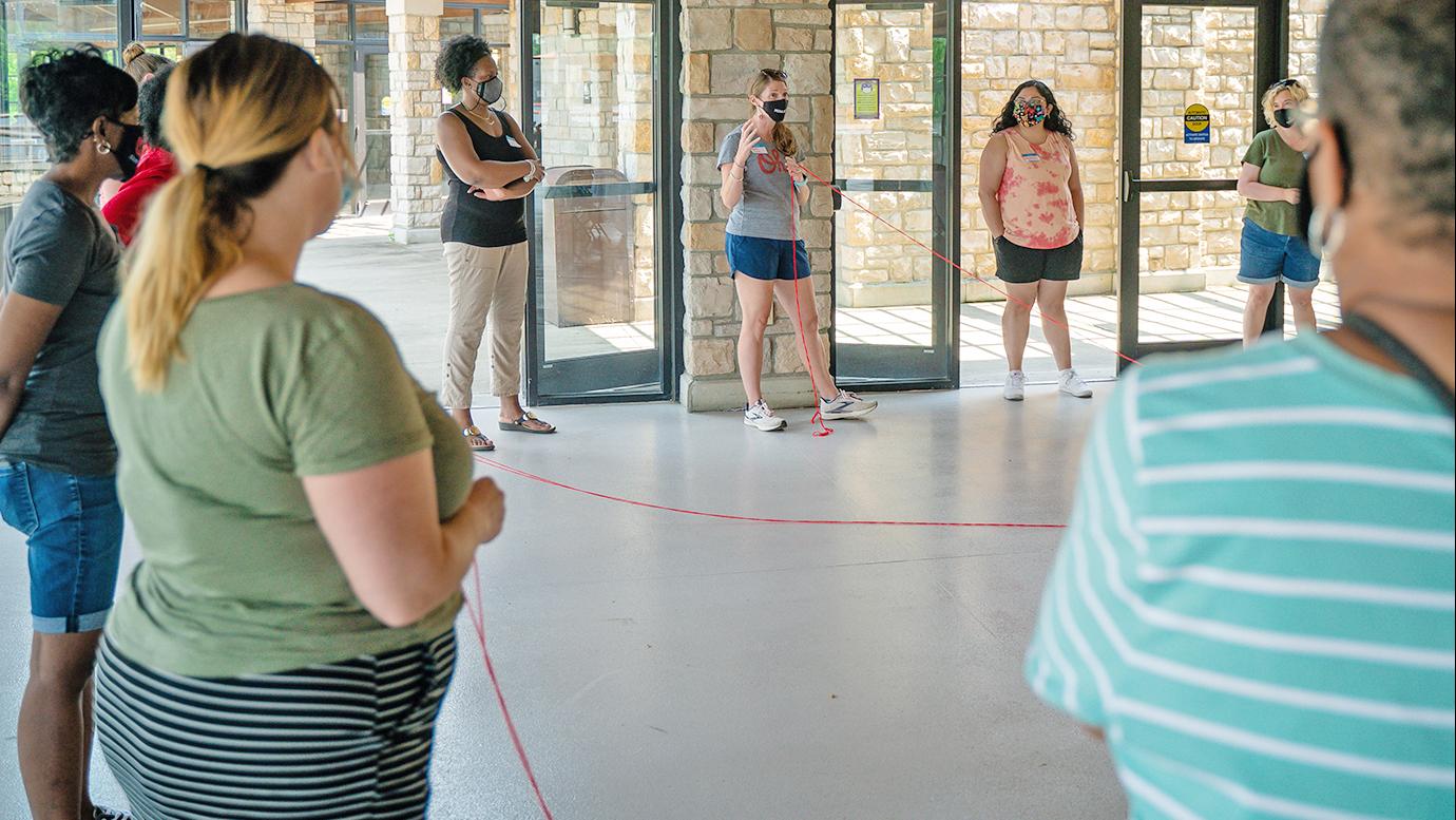 Women standing in a circle in an open-air shelter 