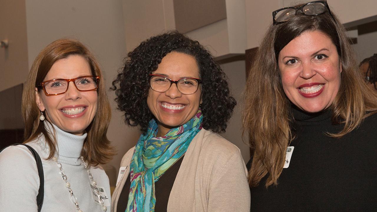 Three women smiling, posing for photo